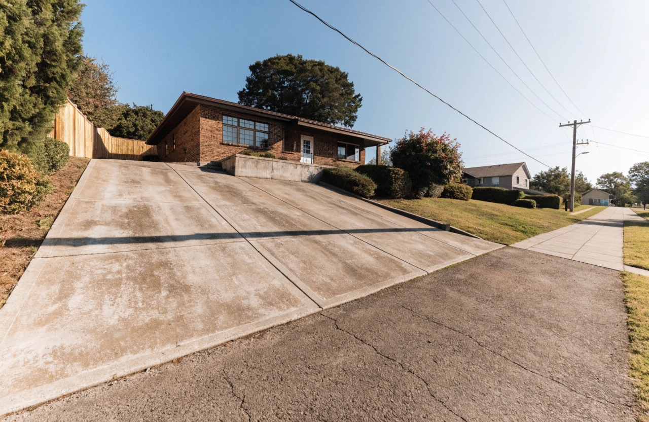 Concrete driveway poured on a graded block outside an elevated Fadden family home