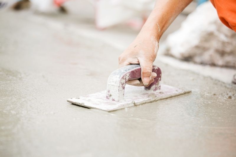 concreter using a trowel to to create a smooth, hard and uniform finish