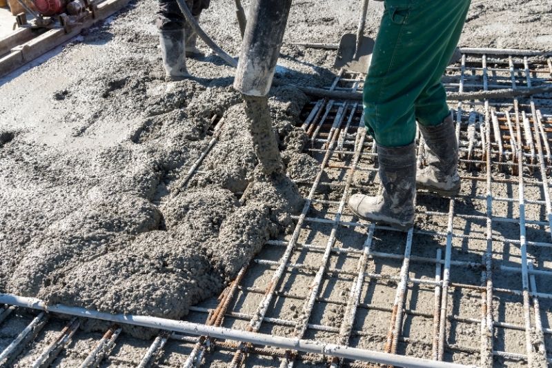 concrete specialist pouring concrete mix in a concrete forms