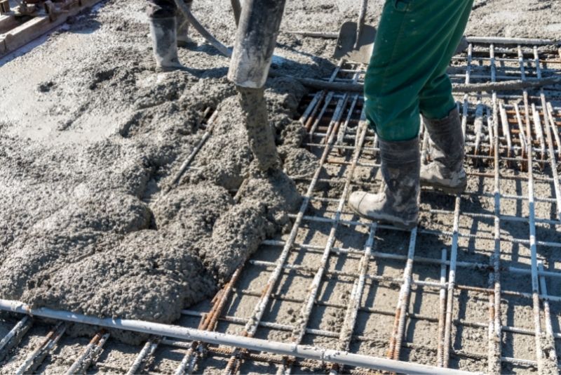 Concrete being poured on a wire mesh