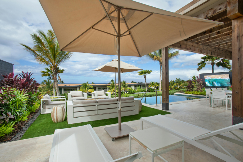 A photo of a concrete patio extending to a pool