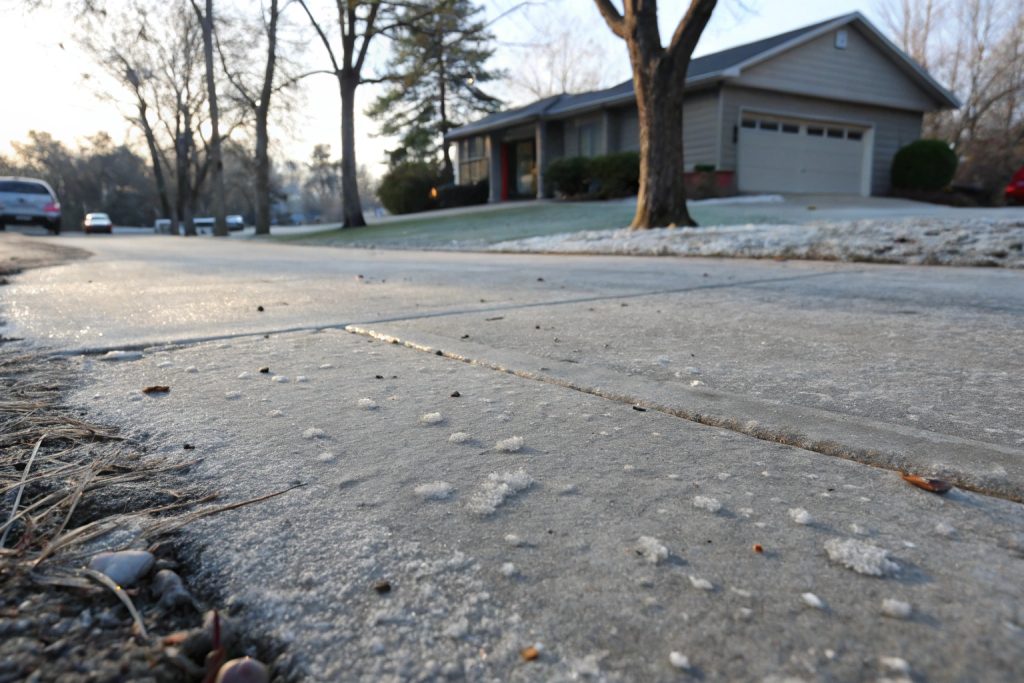Concrete driveway showing freeze-thaw damage including surface scaling and rough patches common in Gungahlin's climate